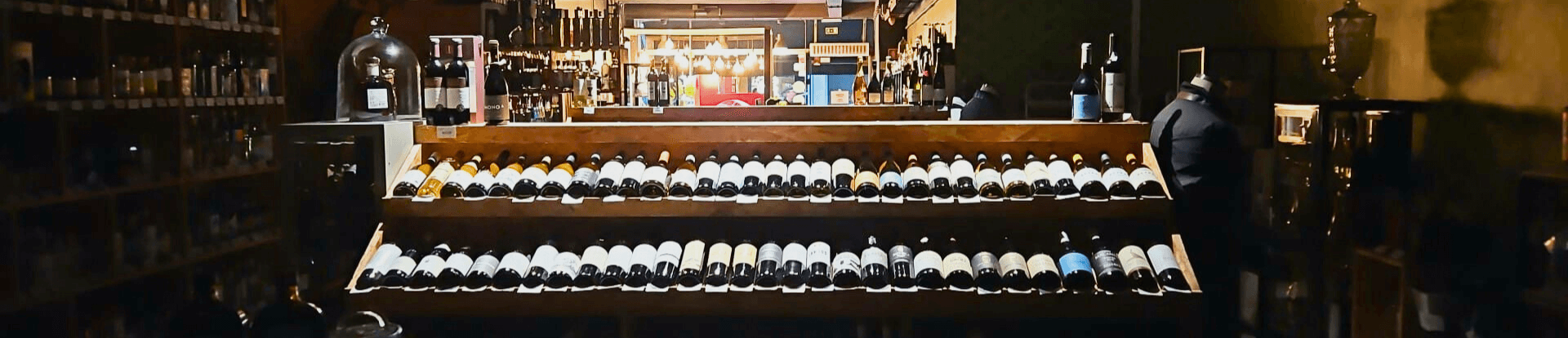 Black pepper and basil wine cellar at night, with only the lights on the wine shelves on.