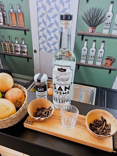 Garrafa de Mezcal San Cosme, bebida artesanal mexicana feita de agave, com rótulo sofisticado, ideal para apreciadores de destilados premium.