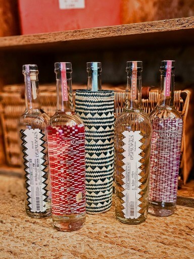 Cinco garrafas de mezcal Derrumbes alinhadas, cada uma representando uma região mexicana distinta