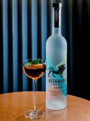 Bottle of Altamura Vodka with glass next to it.